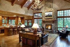 a living room filled with lots of furniture and a fire place in the middle of it