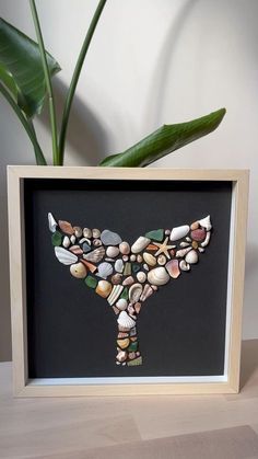 a vase with some rocks in it on a table next to a potted plant