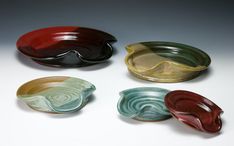 four different colored bowls sitting next to each other