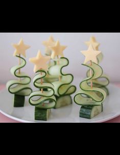 cucumber christmas trees on a white plate with candles in the shape of stars