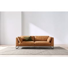 a brown couch sitting on top of a rug