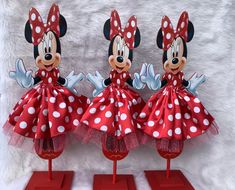 three red and white minnie mouse figurines with polka dots on them, each wearing a matching dress