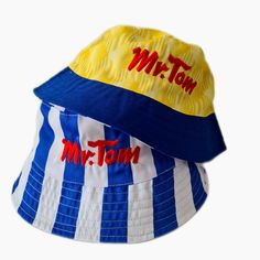 Based on the classic Wednesday kits of the early 90s, these hats optimise the kits in style! Mr Tom was the shirt sponsor, and this has been embroidered onto the front of both sides. Attention has been paid to the kit pattern as can be seen on the away (yellow) side. You can swap and change throughout the day with this Wednesday show stopper! One size fits all! Blue Retro Bucket Hat With Curved Brim, Retro Multicolor Bucket Hat, Wednesday Show, Retro Blue Bucket Hat, Multicolor Upf 50+ Bucket Hat, Adjustable Blue Playful Bucket Hat, Sheffield Wednesday, Reversible Bucket Hat, Football Memorabilia