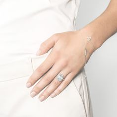 a woman's hand with a diamond ring on her left wrist and a star bracelet on her right arm