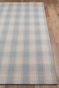 a blue and white plaid rug on a wooden floor