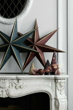 three star decorations on top of a fireplace mantel