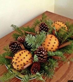 some pine cones are sitting in a bowl with green plants and needles on the table