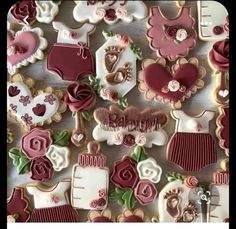 many decorated cookies are arranged on a table together with flowers and hearts in the center