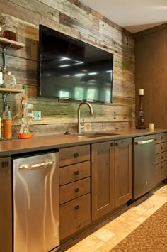 a kitchen with wood paneling and stainless steel dishwasher, microwave, sink, and refrigerator