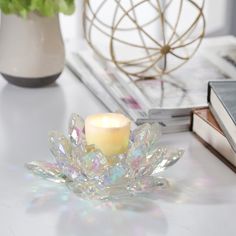 a candle sits on a table next to some books