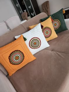 four decorative pillows on a couch in a living room