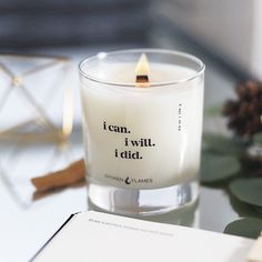 a candle sitting on top of a table next to a book