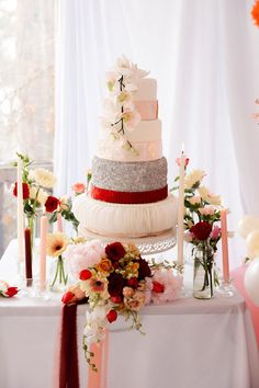 a wedding cake on a table with flowers and candles