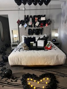 a bed with black and white decorations on the headboard, candles in the shape of a heart