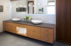 a bathroom with two sinks, mirrors and lights on the wall next to each other