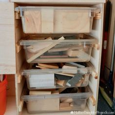 an open refrigerator door with plastic containers and tools in it