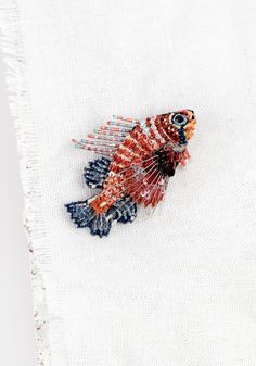 a red and blue fish on a white piece of cloth