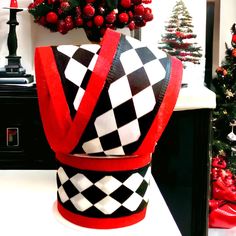 a black and white checkered hat sitting on top of a table next to a christmas tree