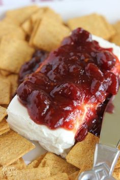 a plate with crackers, cheese and jelly on it