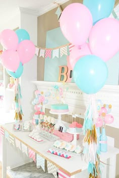 a table topped with lots of balloons and cake