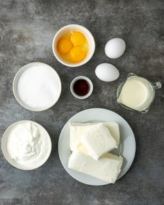 eggs, butter, and other ingredients are arranged on a gray surface with white plates