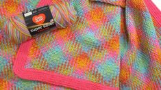 a close up of a knitted blanket with a tag on the end of it