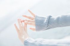 a woman's hand with two fingers on her thumb and one holding the other