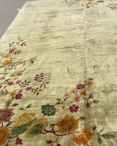 an old rug with flowers and leaves on it