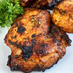 the best damn air fryer chicken thighs recipe on a white plate with parsley