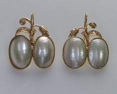 "Timeless and elegant floral design earrings  are made of Mabe pearls, 14K gold, and diamond in 1960s  The high-quality bezel set Mabe pearls  measure approx. 16 X 12 mm. The single cut diamonds, totaling approx. 0.10 CTW, add a touch of sparkle and glamour,  making them perfect for special occasions or everyday wear. The earrings are 1 1/4\" high with hooks, 1\" wide. They are hallmarked 14K and a designer mark J0JT17. Total weight is 11 grams. Excellent vintage condition. Mabe pearls are a type of blister pearl  that is formed on the inside of the shell of a mollusk.  They are known for their large size and iridescent luster." Luxury Oval Pearl Earrings For Formal Occasions, Exquisite Cabochon Earrings For Formal Occasions, Oval High Luster Pearl Earrings For Formal Events, Exquisite Formal Cabochon Earrings, Formal High Luster Oval Pearl Earrings, Elegant Oval Pearl Earrings With High Luster, Elegant Cabochon Earrings For Anniversary, Elegant White Gold Earrings With Cabochon, Elegant White Gold Cabochon Earrings