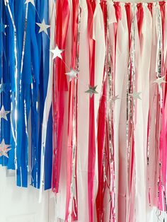 red, white and blue streamers are hanging on the wall next to each other