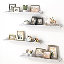 three white shelves with pictures and other items on them