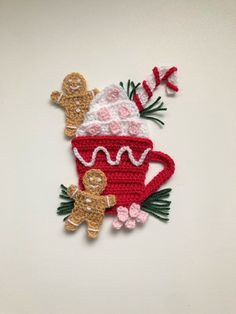 a crocheted coffee cup with two gingerbreads