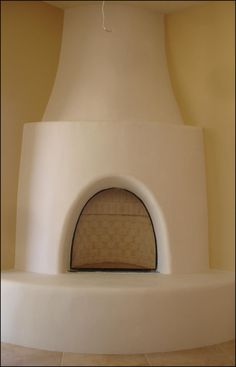 a large white fireplace with a round window in the center and an oven door on top