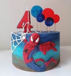 a birthday cake with spiderman decorations on it's top and the number four