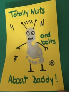 a child's hand holding up a yellow paper with an image of a monster