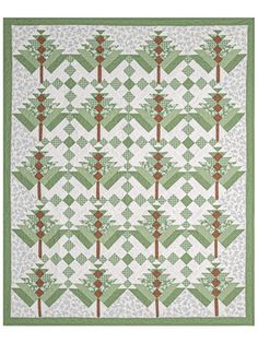 a green and white quilt with trees in the center on top of it, along with an olive green border