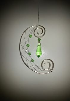 a wind chime with green beads hanging from it's side