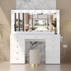 a white vanity with marble counter top and mirror