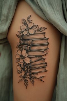 a tattoo with books and flowers on the side of her thigh, as if she were reading