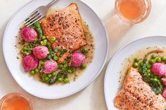 two white plates topped with fish and vegetables