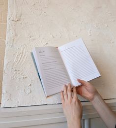 a person is reading a book on the radiator and holding it in their hand