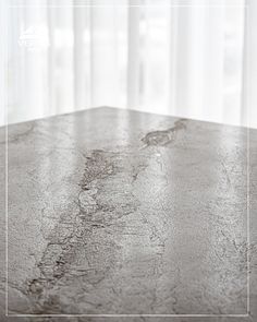 an empty table in front of a window with curtains