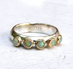 925 silver ring and 14k yellow gold bazel with 5 opals stones: You are looking at a beautiful HAND MADE 14k gold ring with 5 opals stones. The opals stones are setting in 14k gold bezel. It is impressive, powerful and very beautiful ring. This ring can be made to order in any size.  Please note your desired size in the message to seller area at checkout. size stone is 3 mm. width ring: 4mm nickel free Opal Ring Silver, Opal Wedding Band, Opal Solitaire Ring, Jewelry Stacking, Blue Opal Ring, Wedding Ring Ideas, Amethyst Ring Engagement, Silver Opal Ring, White Opal Ring