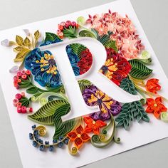 the letter person is made out of paper and decorated with flowers, leaves, and butterflies