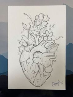 a drawing of a heart with flowers and leaves on it's side in front of mountains