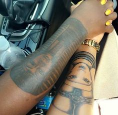 two people with tattoos on their arms sitting next to each other in a motorcycle seat