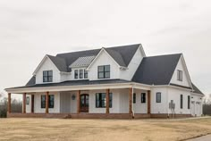 a large white house sitting on top of a grass covered field