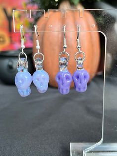 Skull Earrings Handmade Out of Borosilicate Glass These earrings are the perfect & most adorable way to celebrate Halloween or Spooky Szn in any and all settings!  Handmade with love out of borosilicate glass for longevity. Paired with Sterling Silver loops Comes with clear backs on a earring card holder Thank you for supporting our family & small glass business. Spooky Skull Jewelry For Gifts, Purple Earrings As Halloween Gift, Purple Earrings For Halloween Gift, Earring Card Holder, Hand Earrings, Zombie Hand, Spooky Szn, Earring Card, Art Halloween