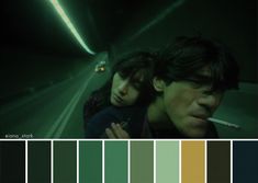 two people standing next to each other in a dark room with green and yellow colors